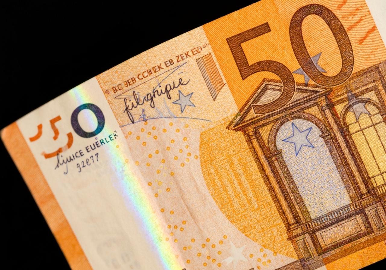 Billet de 50 euros orange tenu à la lumière transparence